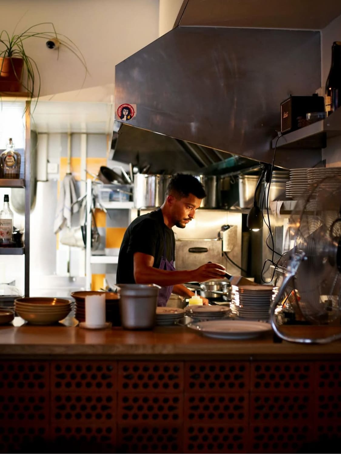 Le chef Allan Ozier concentré au piano dans sa cuisine