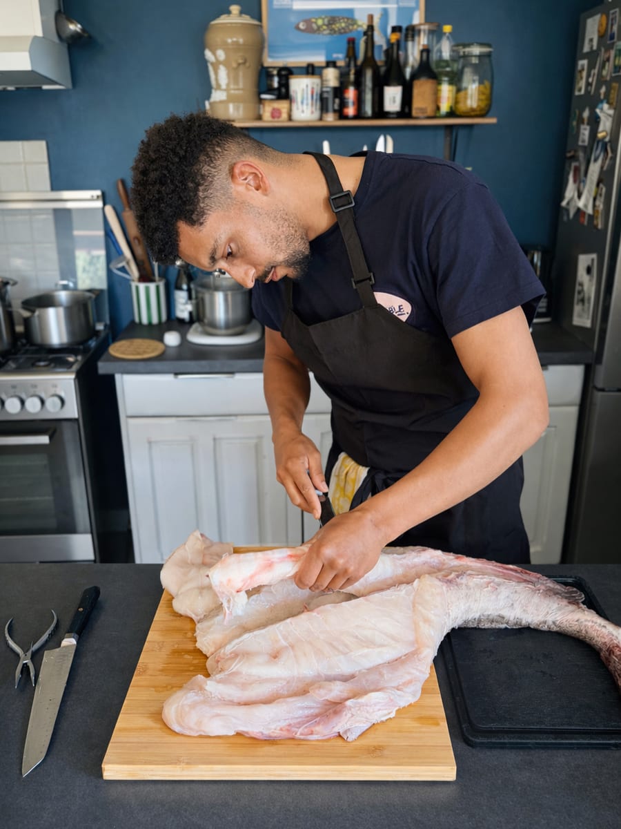 Le chef À TABLE ! lève un poisson en cuisine